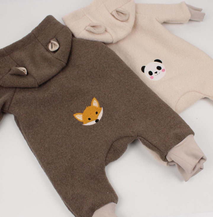 Taupe overall with embroidered fox and beige overall with embroidered panda, flat lay - AnnaKarinna